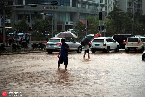 南山區(qū)路人走在馬路上，積水已經(jīng)到小腿中部